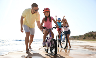 gezin-met-fietsen-op-strand-332x200