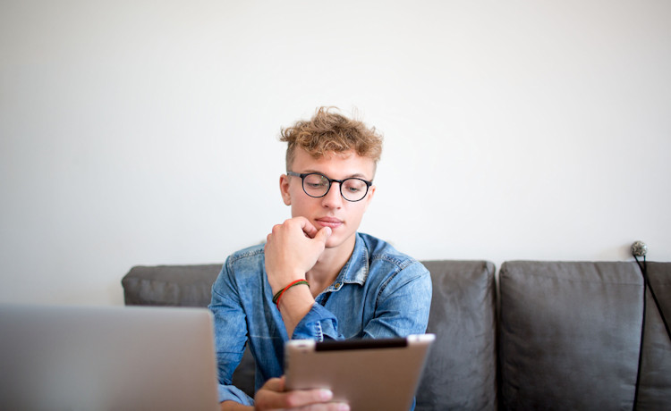 jonge man kijkt op laptop